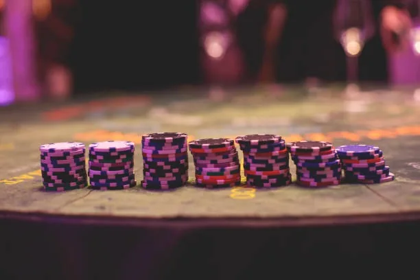 Stacks of purple and black casino chips on a table
